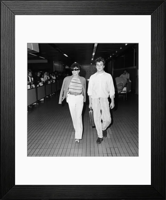 Framed Print : Joan Collins with her son Sacha, 17, arriving at Heathrow from Los Angeles Framed Print : Joan Collins with her son Sacha, 17, arriving at Heathrow from Los Angeles