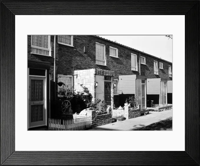 Framed Print : Painted council houses and the unpainted ones - part of a battle of home buying at a Framed Print : Painted council houses and the unpainted ones - part of a battle of home buying at a