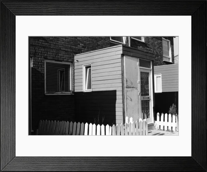 Framed Print : Painted council houses and the unpainted ones - part of a battle of home buying at a Framed Print : Painted council houses and the unpainted ones - part of a battle of home buying at a