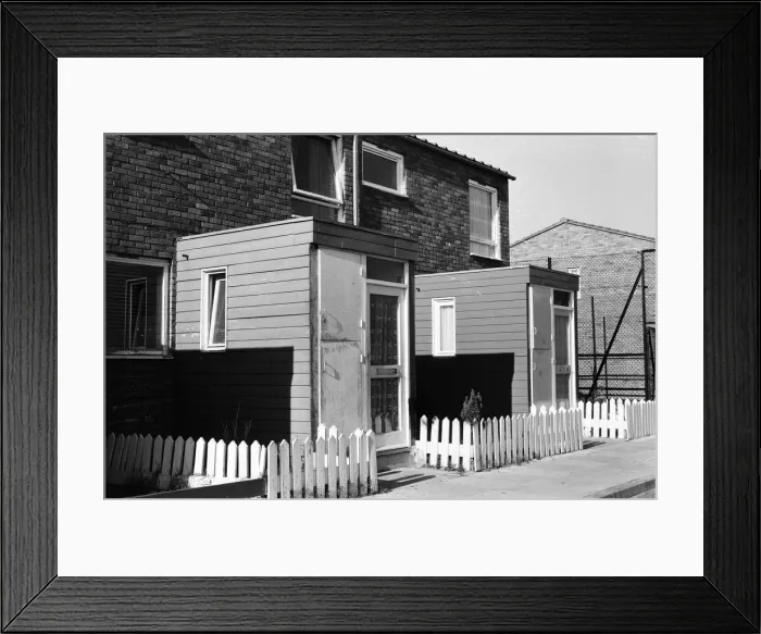Framed Print : Painted council houses and the unpainted ones - part of a battle of home buying at a