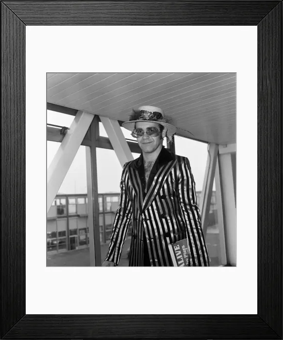 Framed Print : Pop star Elton John wearing a hat trimmed with flowers and feathers Framed Print : Pop star Elton John wearing a hat trimmed with flowers and feathers