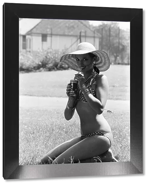Young lady cools down with a refreshment as she enjoys the summer heatwave, Teesside