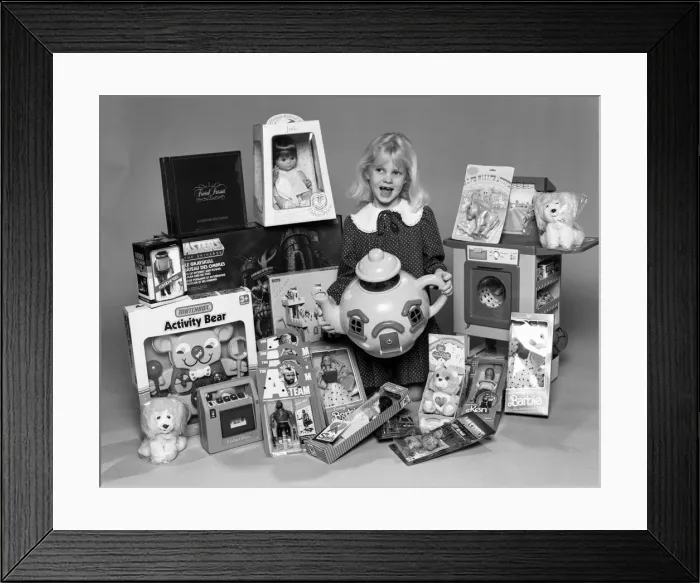 Framed Print : A young girl with a selection of childrens toys for Christmas. 6th December 1984