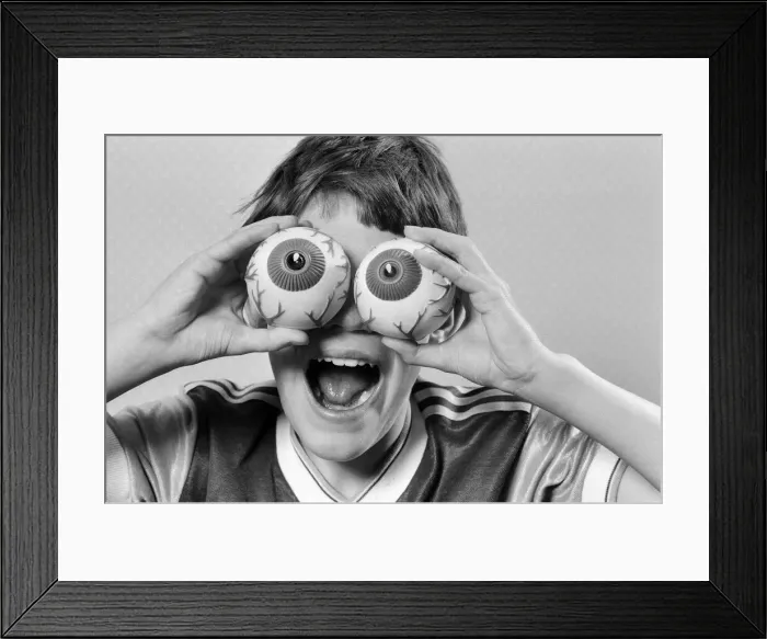Framed Print : A young boy holding fake eye ball toys up to his eyes. 21st October 1986 Framed Print : A young boy holding fake eye ball toys up to his eyes. 21st October 1986