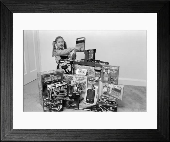 Framed Print : A lucky child surrounded by a selection of electronic games available in the shops this Framed Print : A lucky child surrounded by a selection of electronic games available in the shops this