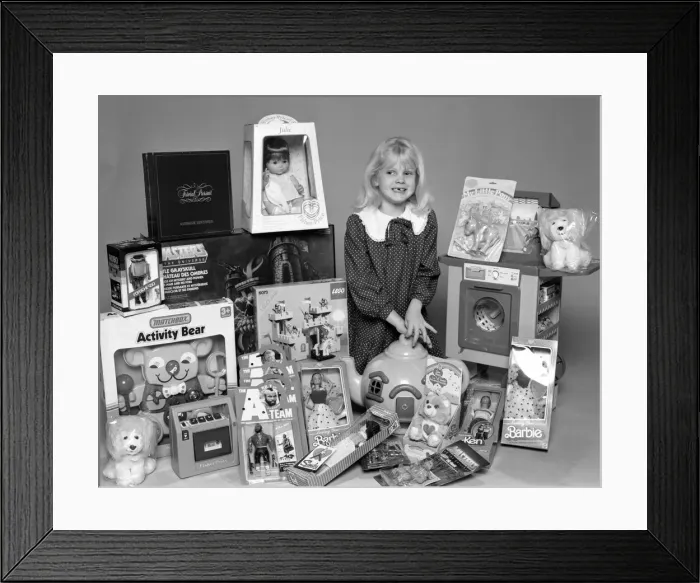 Framed Print : A young girl with a selection of childrens toys for Christmas. 6th December 1984 Framed Print : A young girl with a selection of childrens toys for Christmas. 6th December 1984
