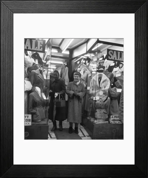 Framed Print : Two women shoppers peruse the garments for sale in a un-named East End clothes shop Framed Print : Two women shoppers peruse the garments for sale in a un-named East End clothes shop