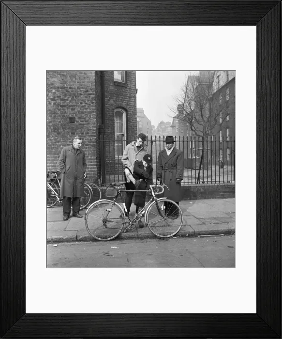 Framed Print : Father watches his son trying out cycles for sale at the flea market in Club Row