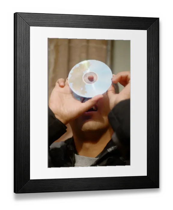Framed Print : A man watching the solar eclipse through a hole in a CD in Chester. 11th August 1999