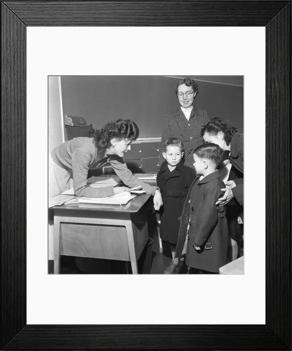 Framed Print : Teacher greets a new addition to her class and introduces him to one of his new class