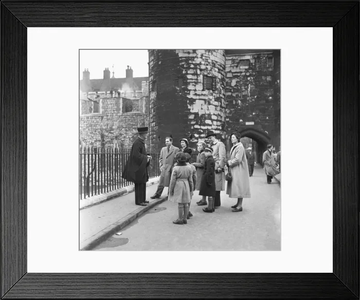 Framed Print : Visitors to the Tower of London are showing around the castle by one of the resident Framed Print : Visitors to the Tower of London are showing around the castle by one of the resident