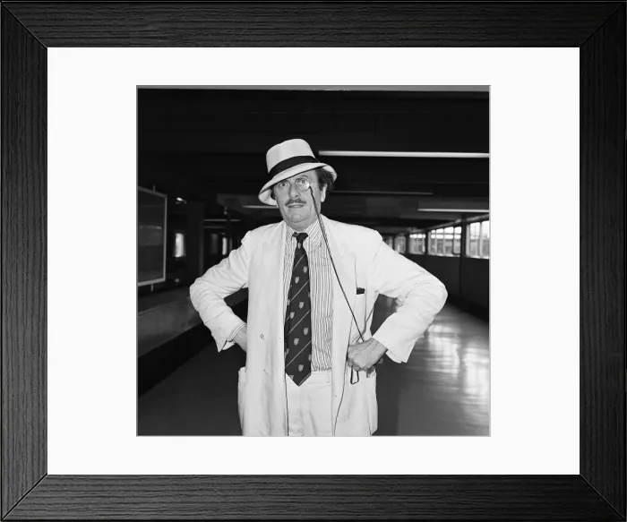 Framed Print : Barry Humphries leaving Heathrow Airport for New York. 10th August 1983