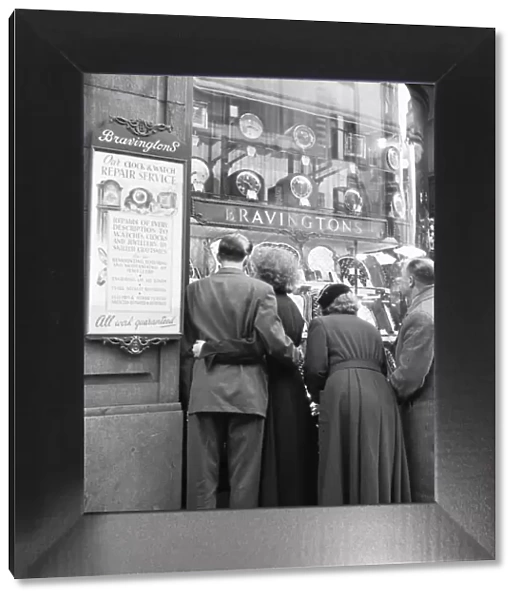 Couple looking at engagement rings in the window of Bravingtons in Fleet Street