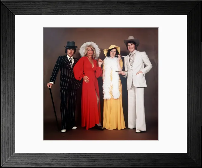 Framed Print : SANDY JARDINE AND KENNY DALGLISH WITH THEIR WIVES at a party in the 1970s hat suit