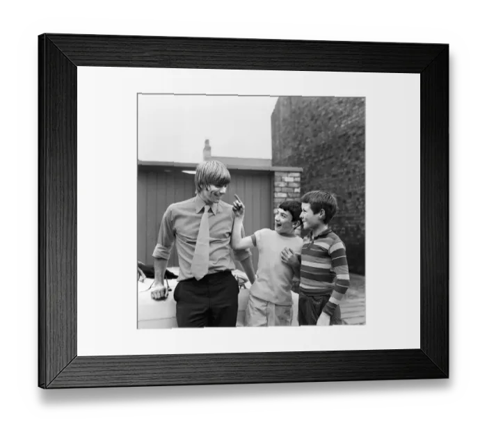 Framed Print : Liverpool footballer Alun Evans speaks to two young fans who inspect his damaged eye as