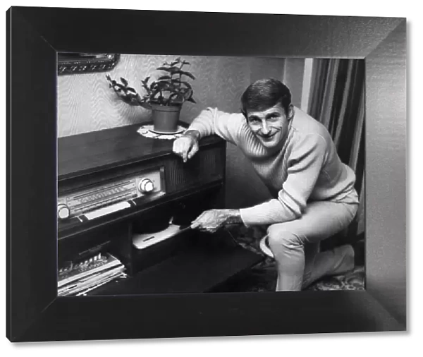 Liverpool footballer Roger Hunt listening to music at home. Circa 1966
