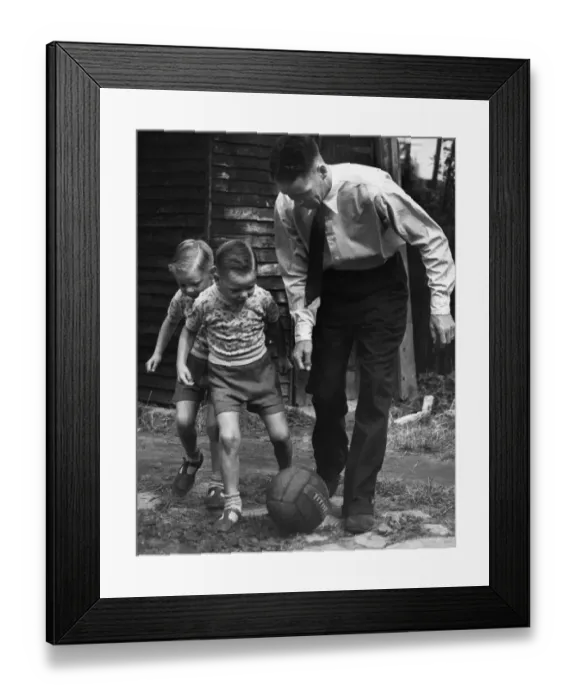 Framed Print : Liverpool footballer Billy Liddell playing football with his twin boys in the back garden Framed Print : Liverpool footballer Billy Liddell playing football with his twin boys in the back garden