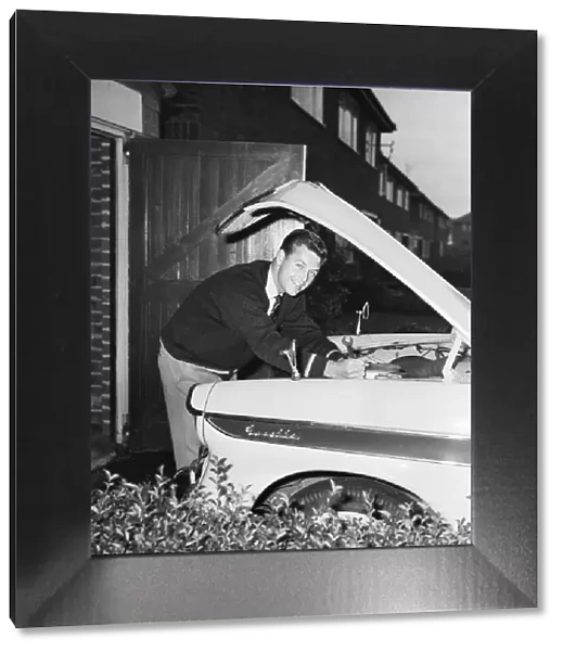 Liverpool footballer Gordon Milne, pictured at his home, checking the engine of his car