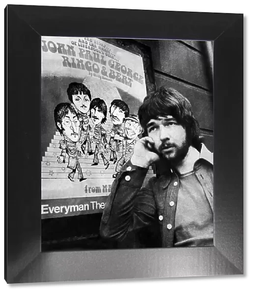 Liverpool playwright Willy Russell poses besides a poster for his play John, Paul, George