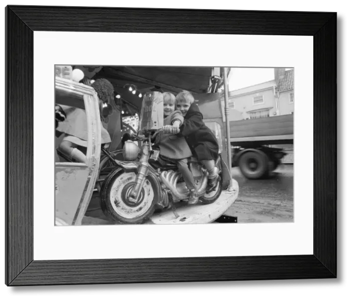 Framed Print : Brother and sister riding a motorcycle on a childs roundabout at the Northallerton Framed Print : Brother and sister riding a motorcycle on a childs roundabout at the Northallerton