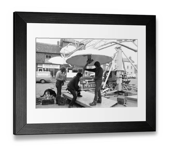 Framed Print : Fairground workers assembly a ride in Stokesley in preparation of the annual fair