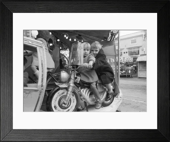 Framed Print : Brother and sister riding a motorcycle on a childs roundabout at the Northallerton Framed Print : Brother and sister riding a motorcycle on a childs roundabout at the Northallerton