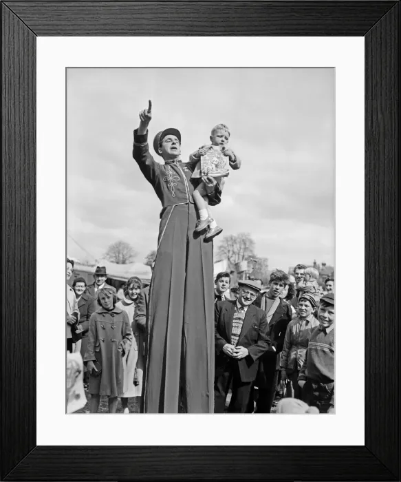 Framed Print : The Bertram Mills Circus comes to town as one worried little boy looks down from the arms Framed Print : The Bertram Mills Circus comes to town as one worried little boy looks down from the arms