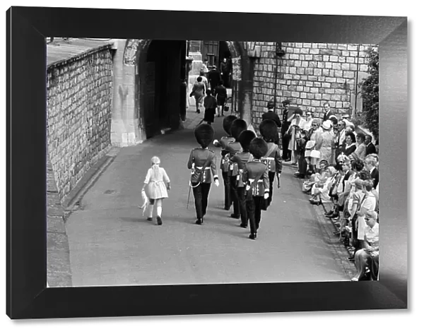 Garter Procession at Windsor Castle. A little girl joins the Guards as they march into