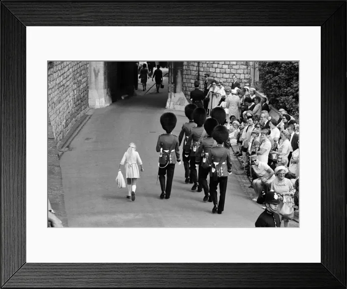 Framed Print : Garter Procession at Windsor Castle. A little girl joins the Guards as they march into Framed Print : Garter Procession at Windsor Castle. A little girl joins the Guards as they march into