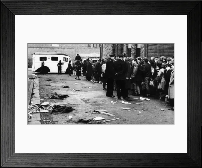 Framed Print : A St Johns Ambulance stands by and assorted litter covers the roadway in Bridport street