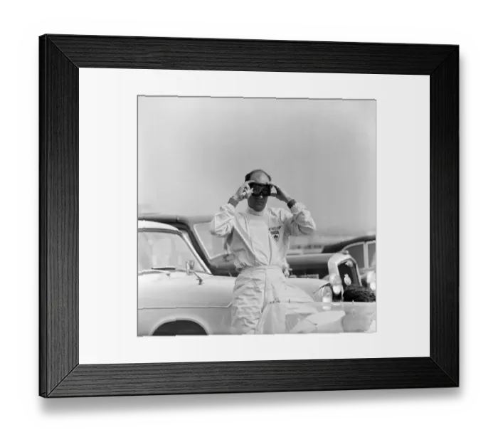 Framed Print : International 200 at Aintree motor circuit. Stirling Moss adjusts his goggles