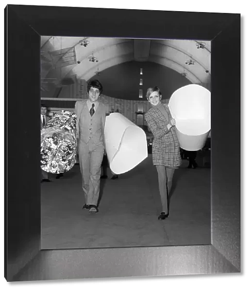 Twiggy with her manager, Justin de Villeneuve carrying some of the paper chairs at