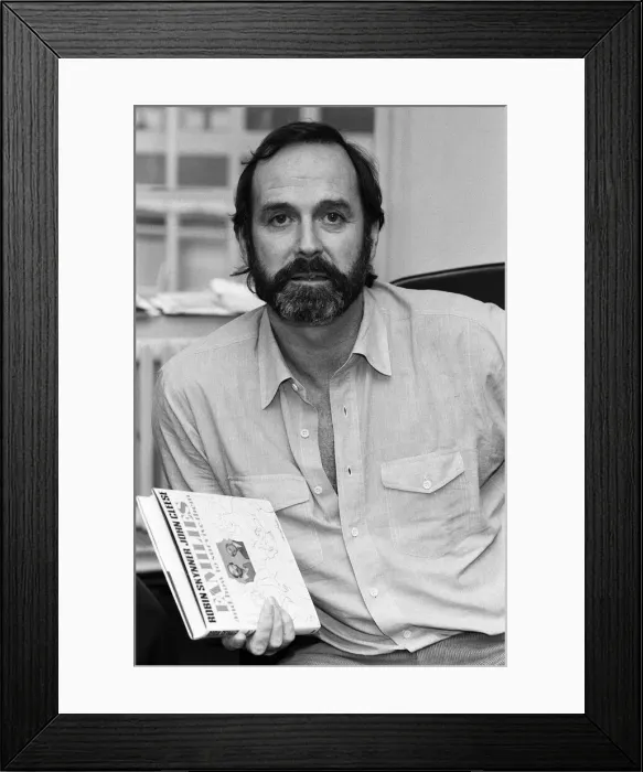 Framed Print : John Cleese with a copy of his book Families And How To Survive Them