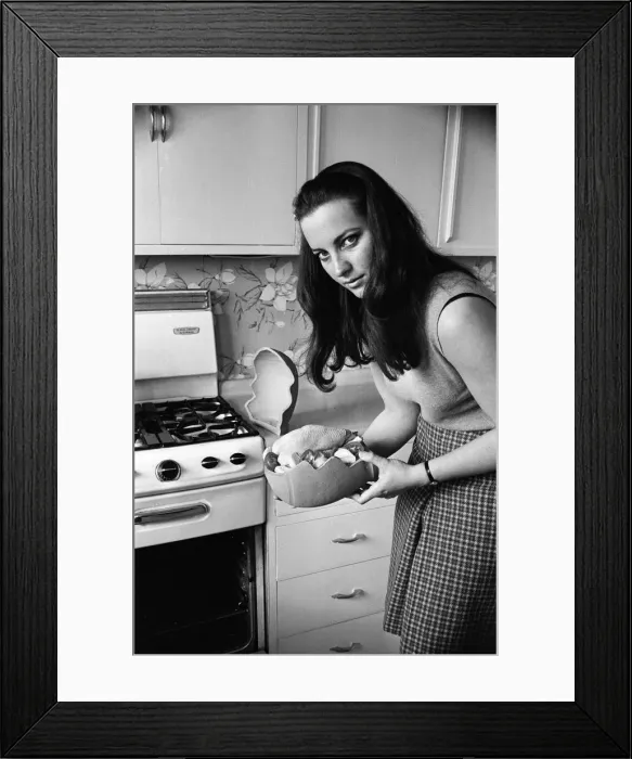 Framed Print : A woman in a kitchen cooking a chicken with a Bobo Pot. 29th March 1967