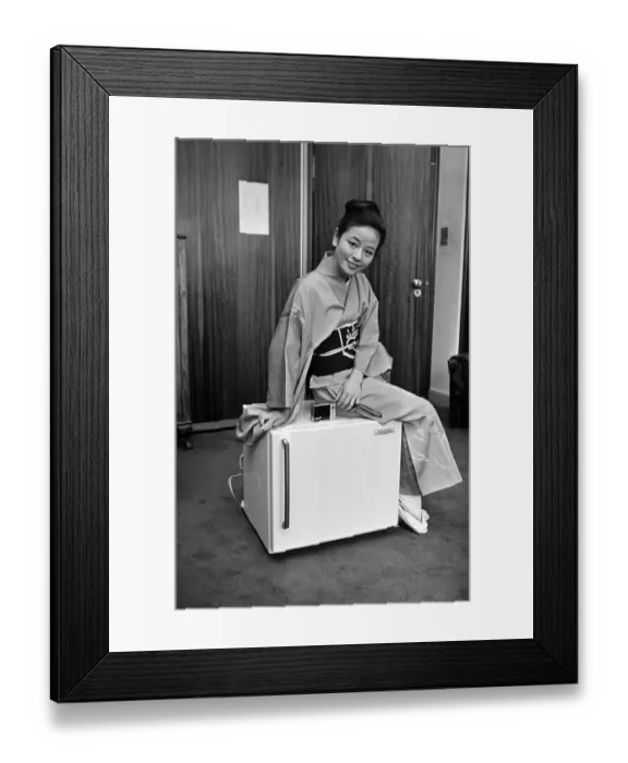 Framed Print : A woman wearing a Kimono sitting on a Japanese food freezer. 26th July 1965