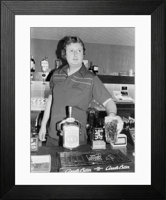 Framed Print : British dart player Eric Bristow pictured at the pub, serving drinks behind the bar Framed Print : British dart player Eric Bristow pictured at the pub, serving drinks behind the bar