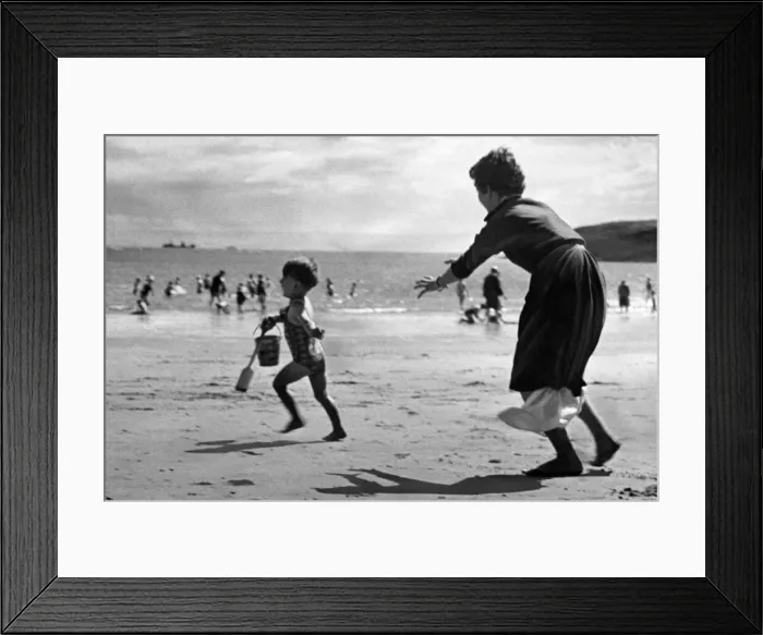 Framed Print : Three year old John Cromwell running away from his mother on the beach at Barry island