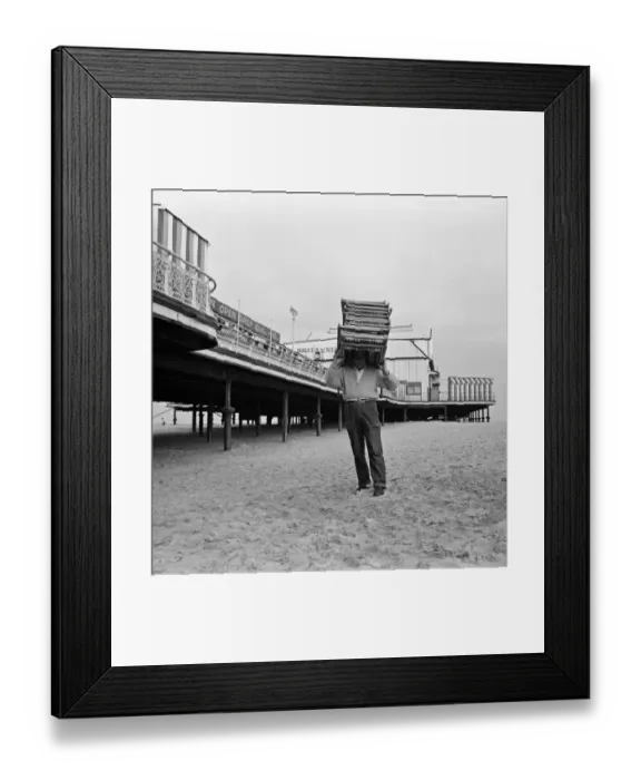 Framed Print : A deck chair attendant carrying deck chairs on his head. Great Yarmouth, Norfolk