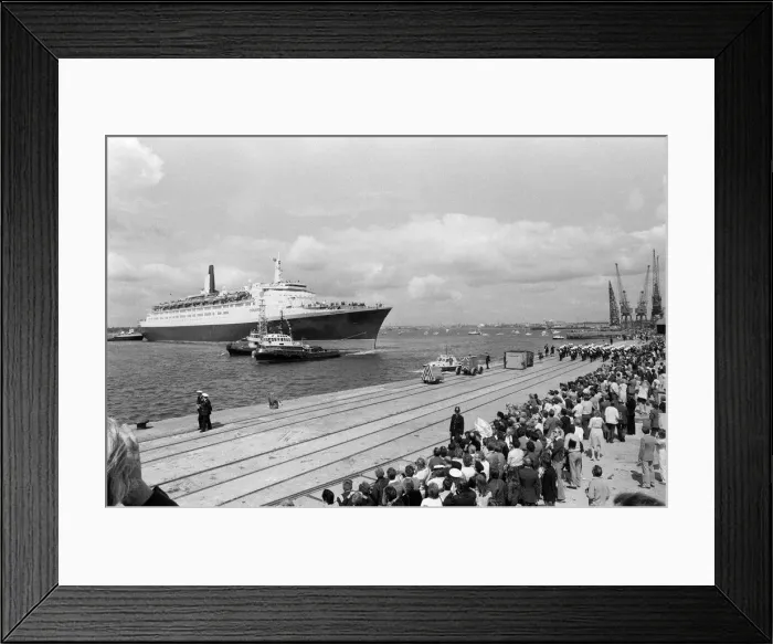 Framed Print : QE2 returns home to Southampton. Union Jacks are festooned on cars, draped on shoulders