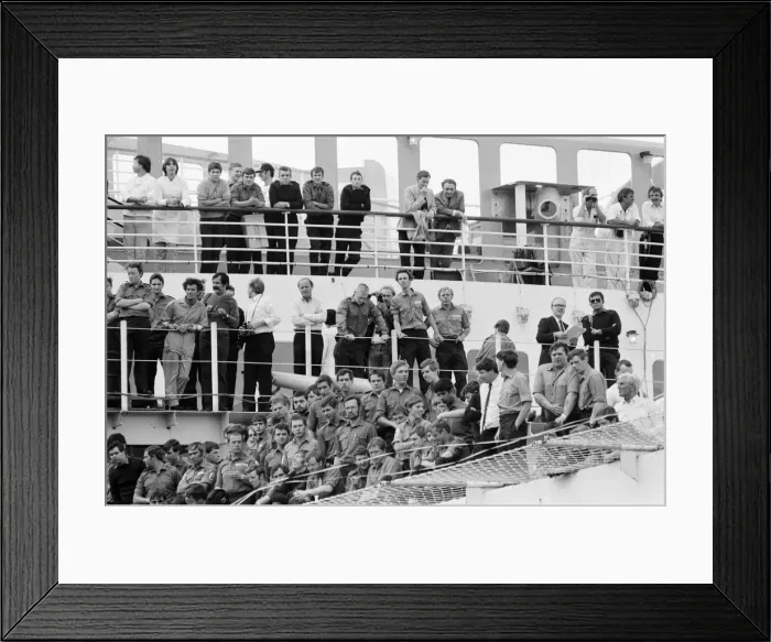 Framed Print : QE2 returns home to Southampton. Union Jacks are festooned on cars, draped on shoulders