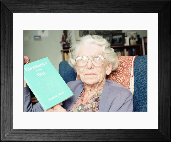 Framed Print : Elizabeth Wilson, Author with a copy of her book, Encounters on the Way, Circa 1998