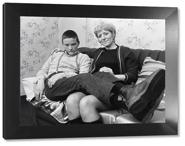 Fifteen year old skinhead Chris Harward poses at home with his mother Joan at their flat