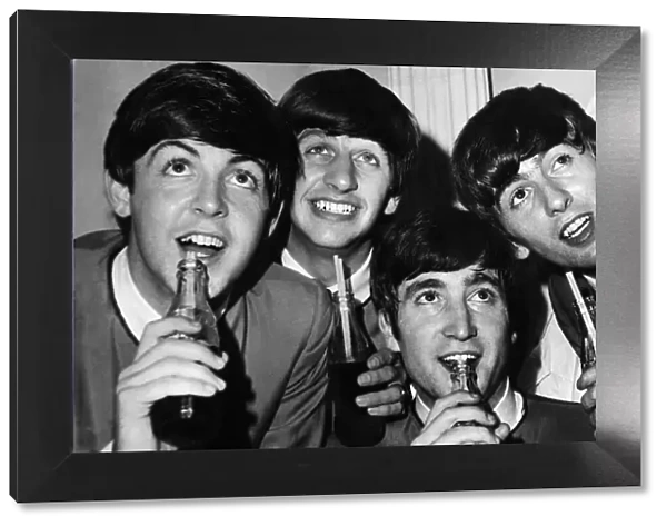 British pop stars The Beatles pose drinking bottles of Coca Cola during a photoshoot