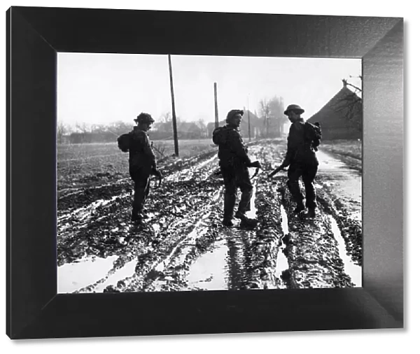British army soldiers making their way up to the front line in Holland through deep mud