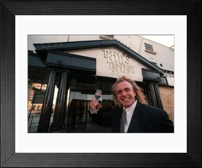 Framed Print : English nightclub owner Peter Stringfellow posing with a glass of champagne outside Framed Print : English nightclub owner Peter Stringfellow posing with a glass of champagne outside