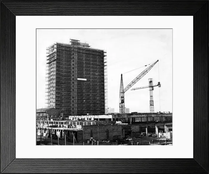 Framed Print : A 22-storey block - shops at ground level, flats above - dominates the scene as work goes