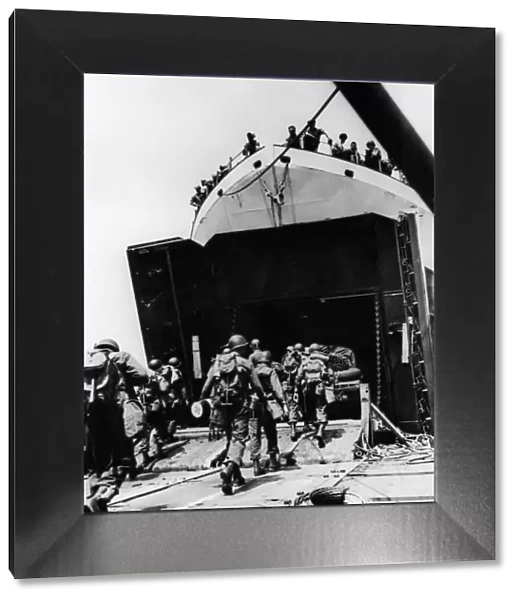 Members of a combat engineer unit march abroad an LST at an English port