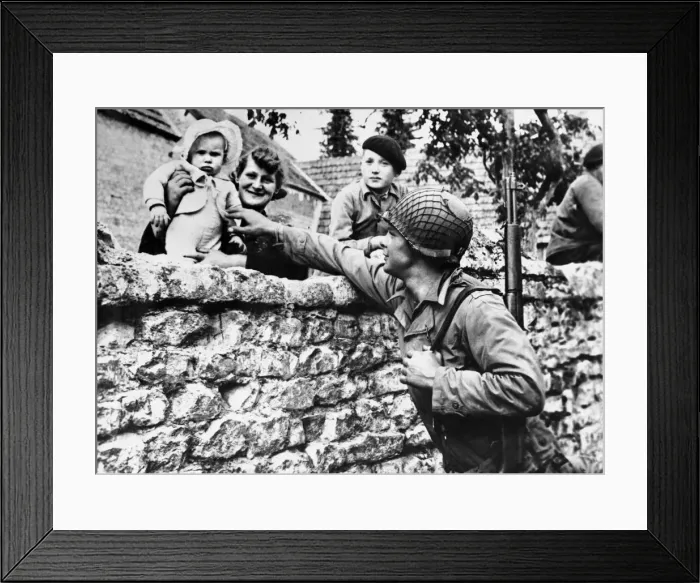 Framed Print : French civilians lean over their garden wall to greet an american solider of the allied