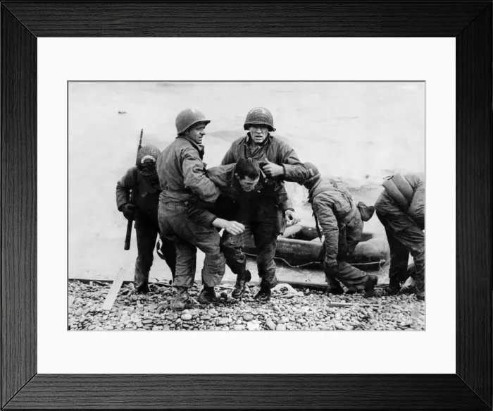 Framed Print : A survivor from a sunk American landing craft is helped ashore on Omaha beach, Normandy Framed Print : A survivor from a sunk American landing craft is helped ashore on Omaha beach, Normandy