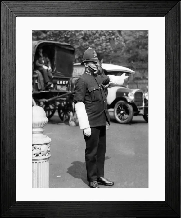 Framed Print : A London policeman on traffic duty with heavy bulk helmet, tunic Framed Print : A London policeman on traffic duty with heavy bulk helmet, tunic